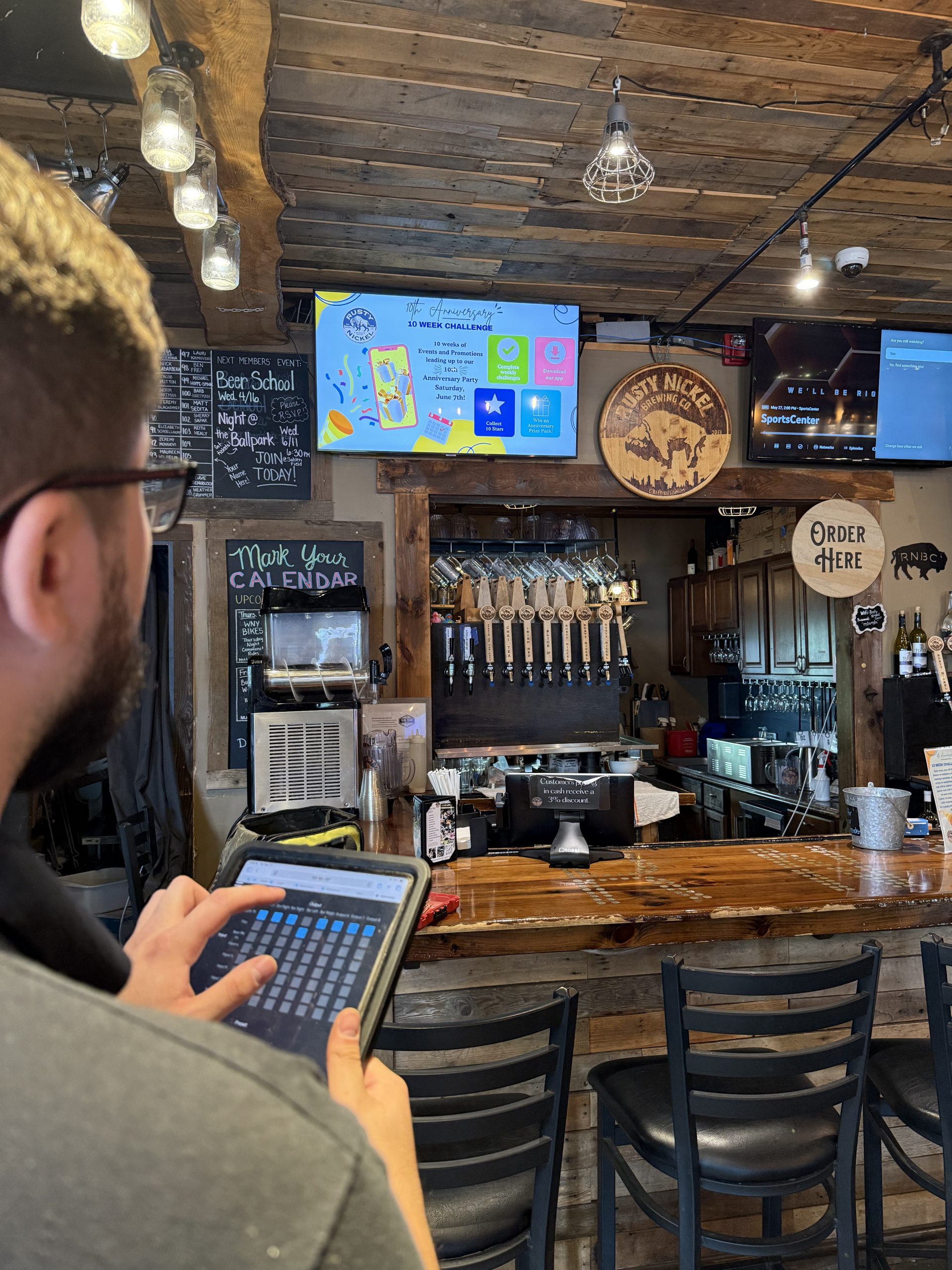 Technician working at Rusty Nickel on a tablet for custom AV system